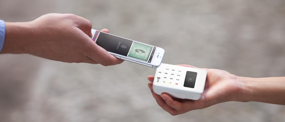 Kontaktlose Bezahlung mit Apple Pay in Verbindung mit American Express Smartphone mit virtueller American Express wird zur Bezahlung an SumUp Air Kartenleser gehalten